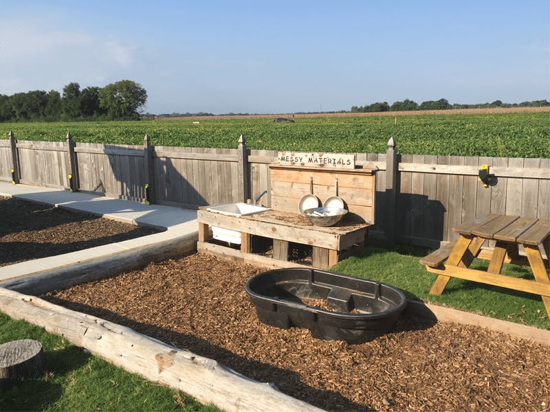Outdoor play area with a wooden mud kitchen and picnic table