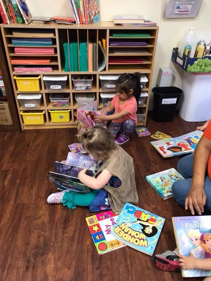 Two children sitting on the floor with books