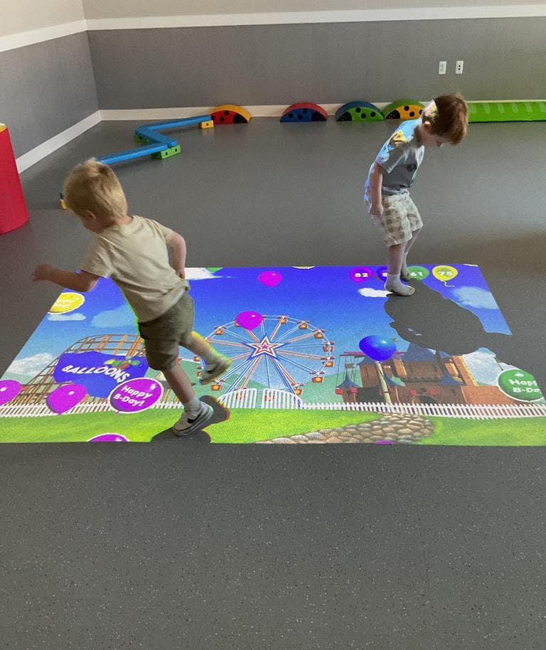 Two children playing on an interactive floor projection