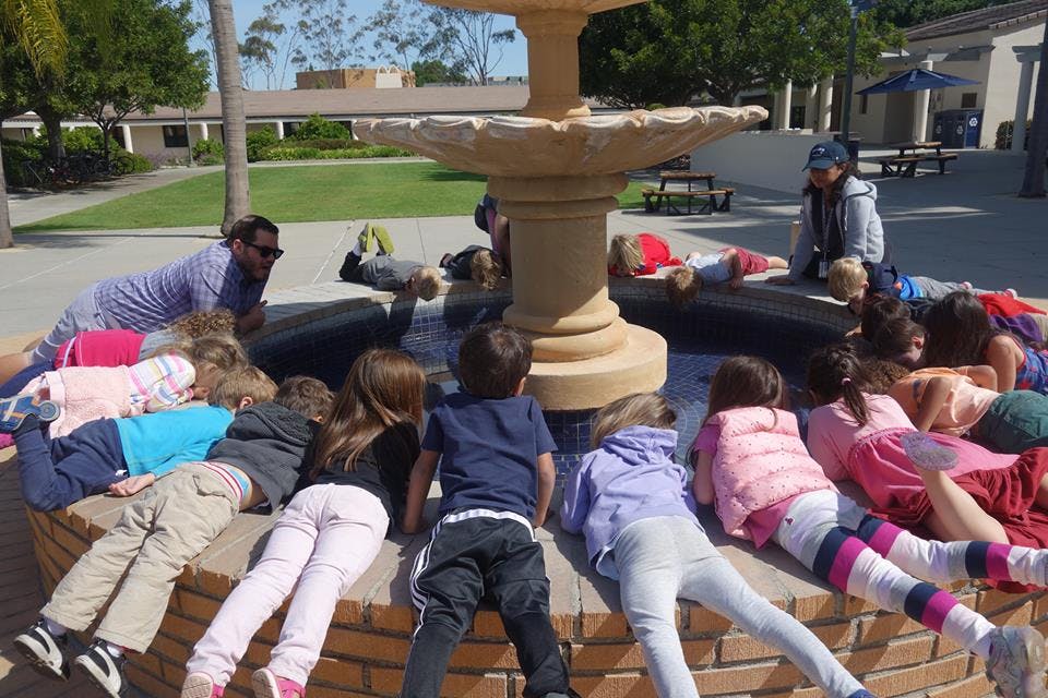 People and children gathered around a fountain