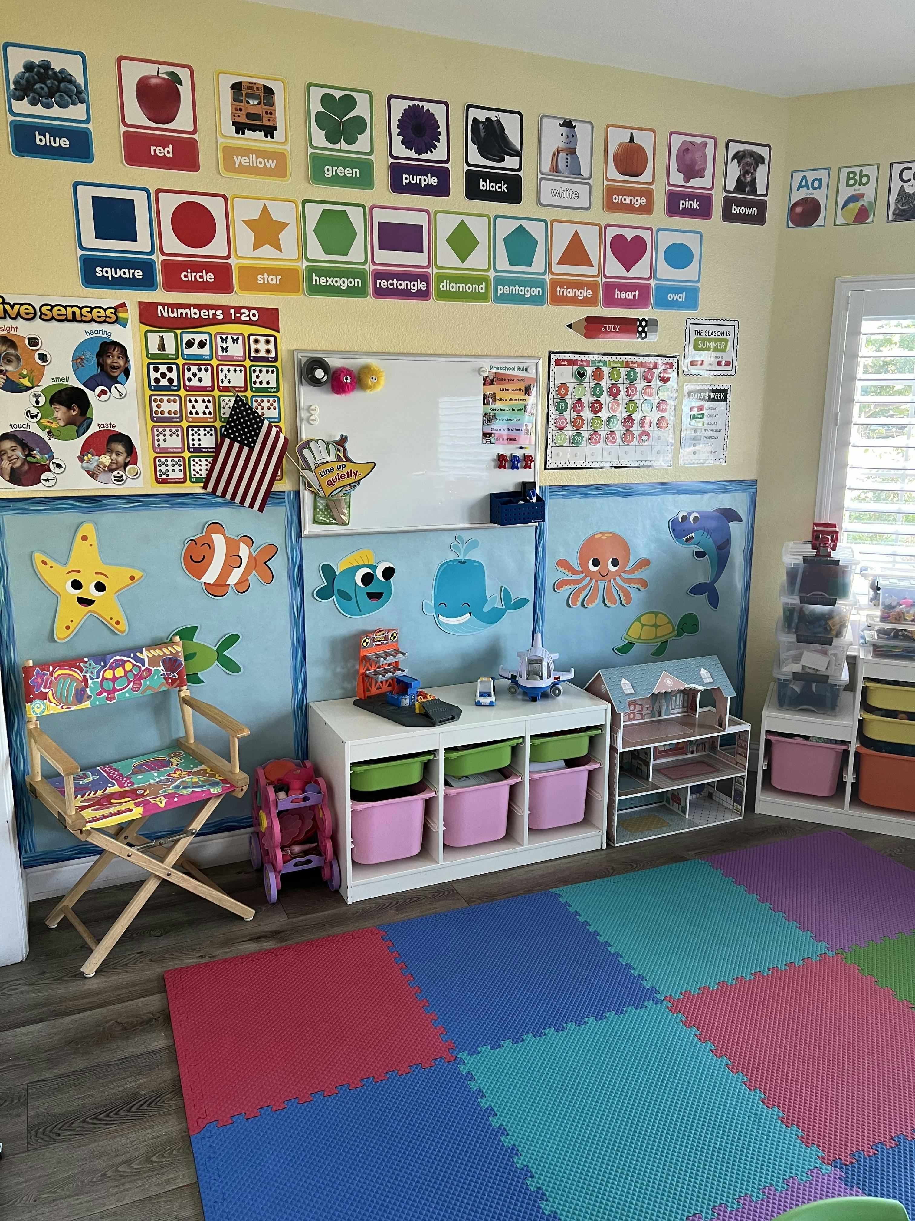 Classroom with educational posters, whiteboard, and colorful play mats