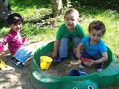Three children playing in a sandbox