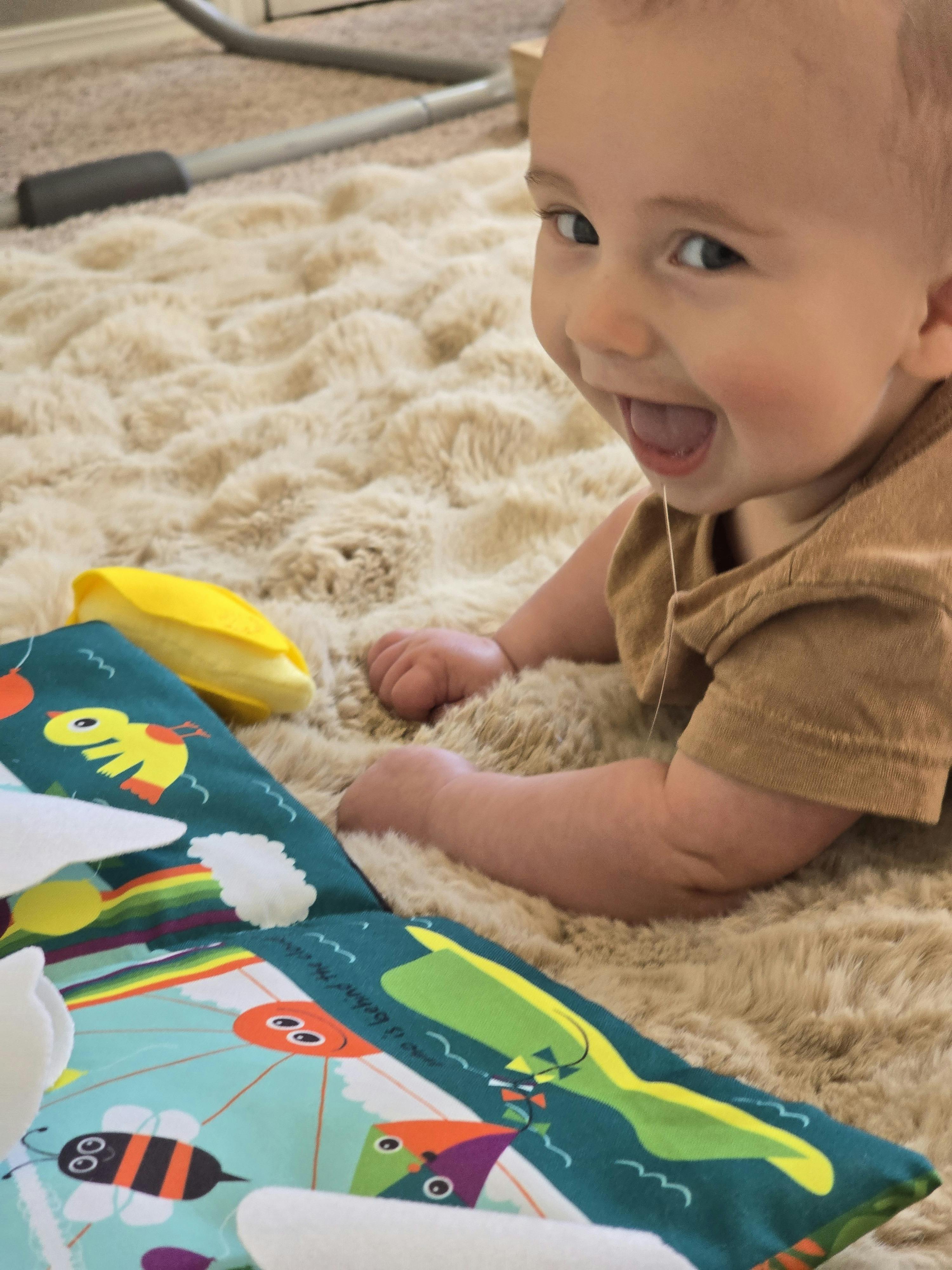 Child on a rug with a colorful play mat