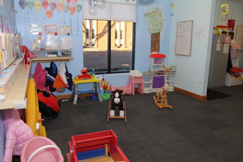 Playroom with toys, including a rocking horse and stuffed animal in a chair