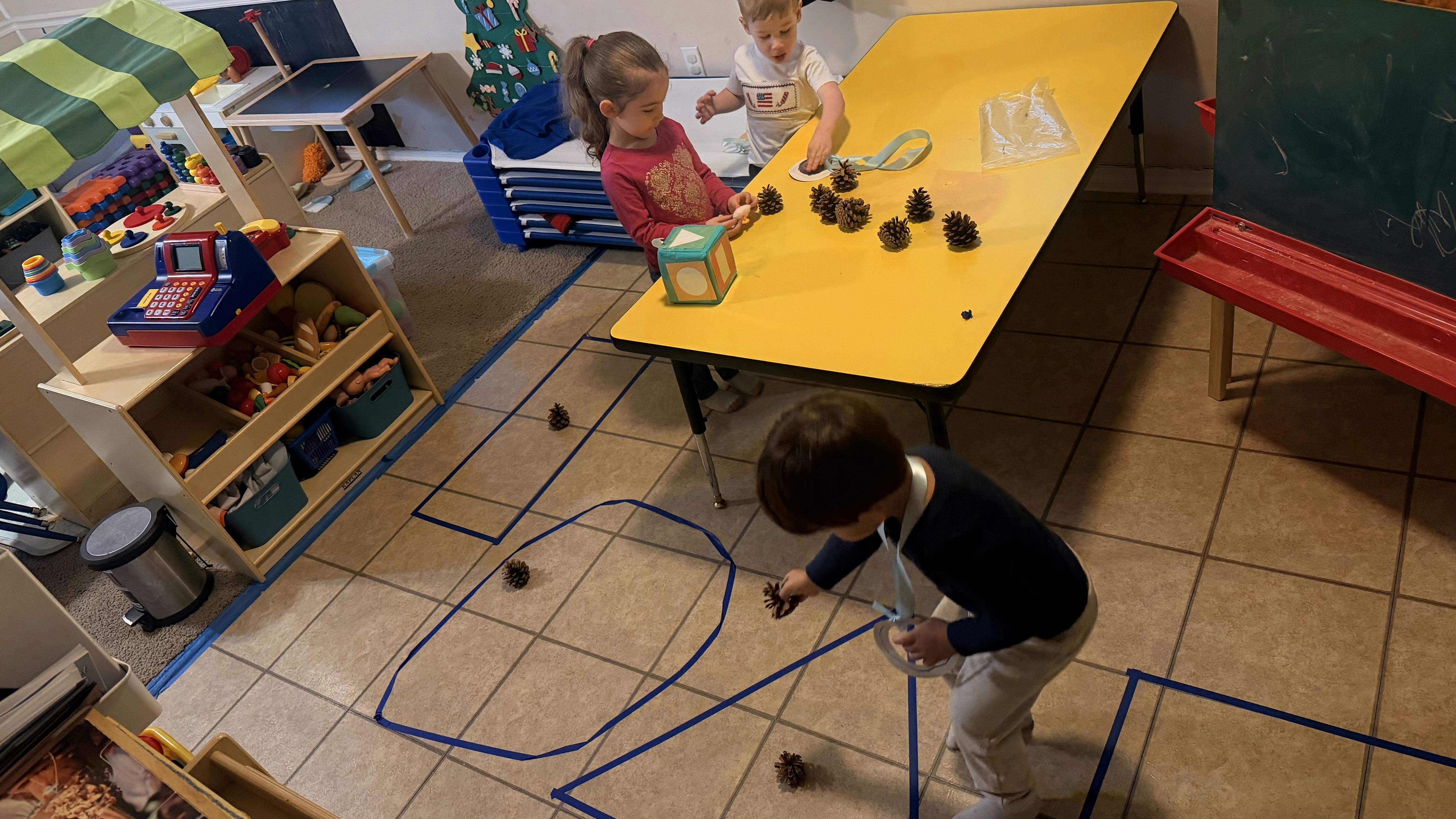 Children playing with pinecones in a classroom