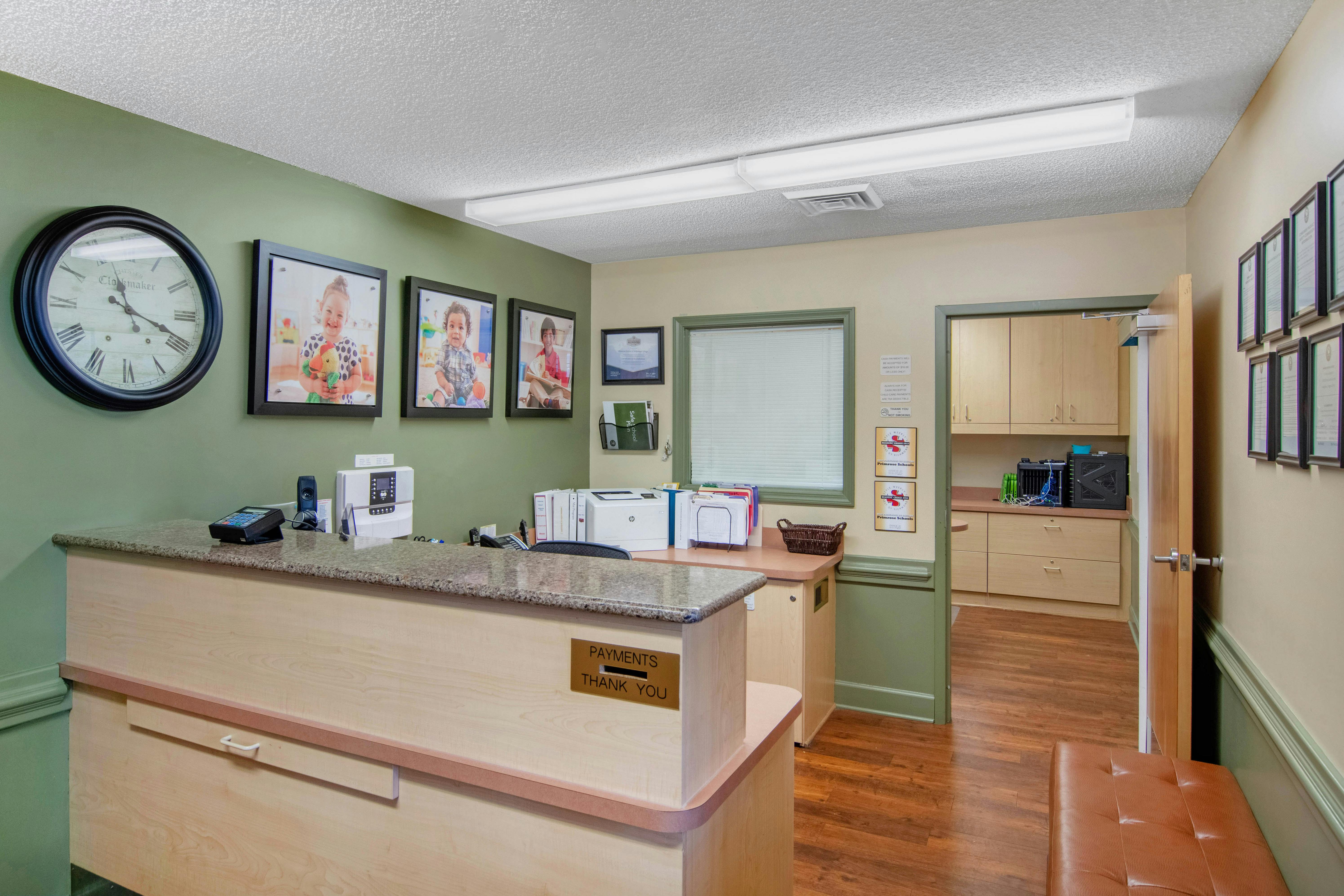 Reception desk with framed pictures of children on the wall