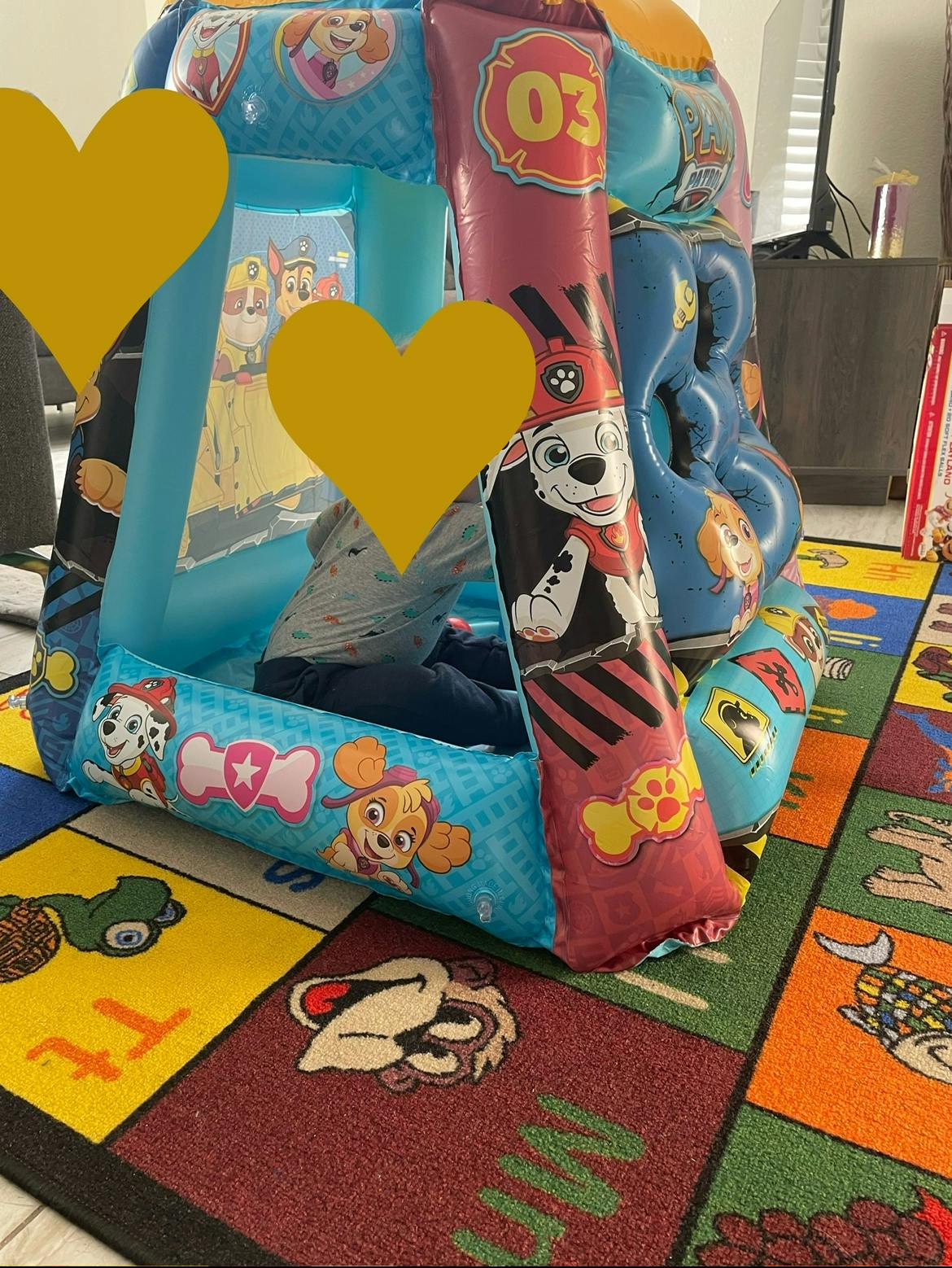 Child inside an inflatable play structure with cartoon characters