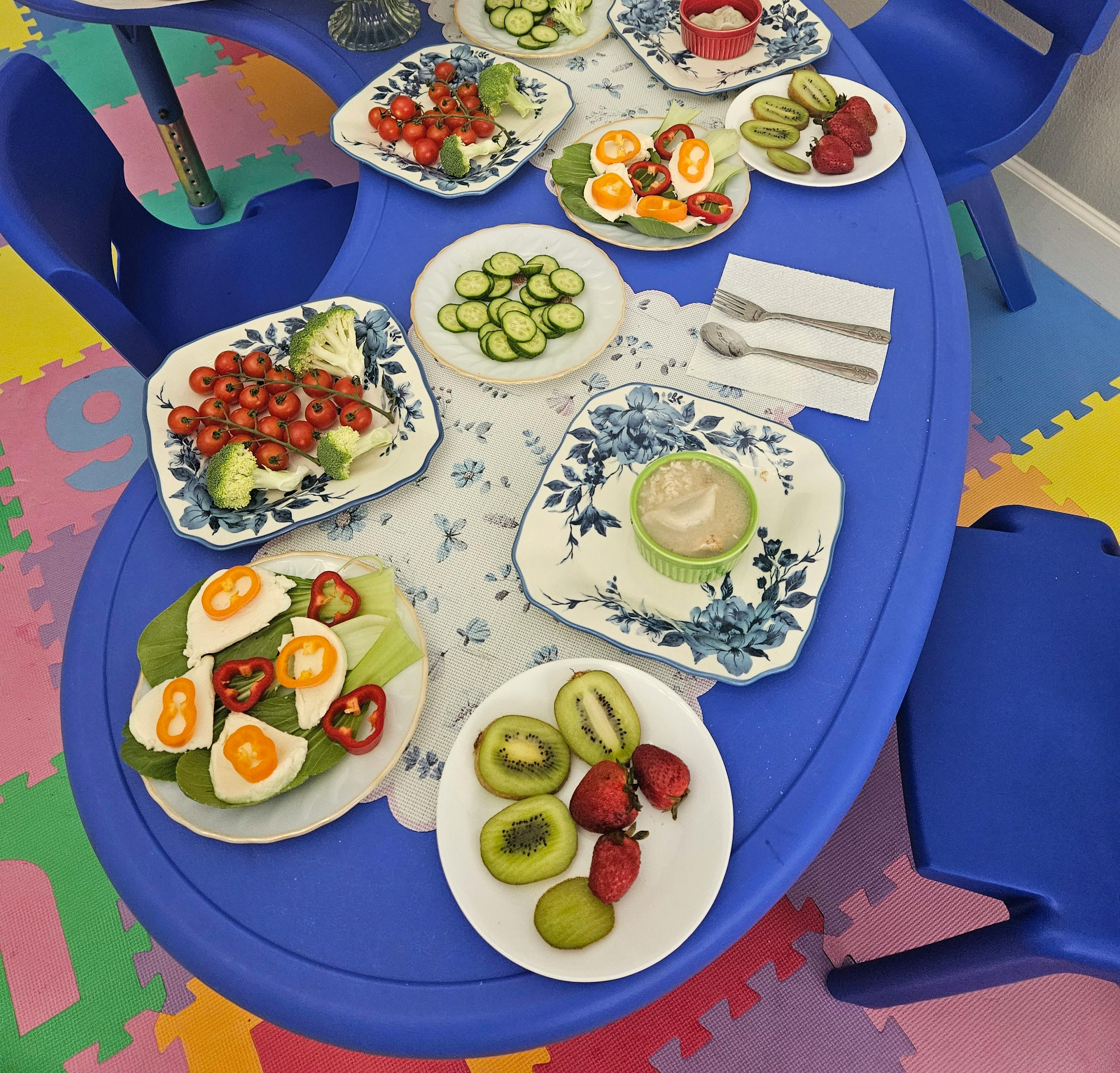 Plates of fresh fruit and vegetables served on a blue table