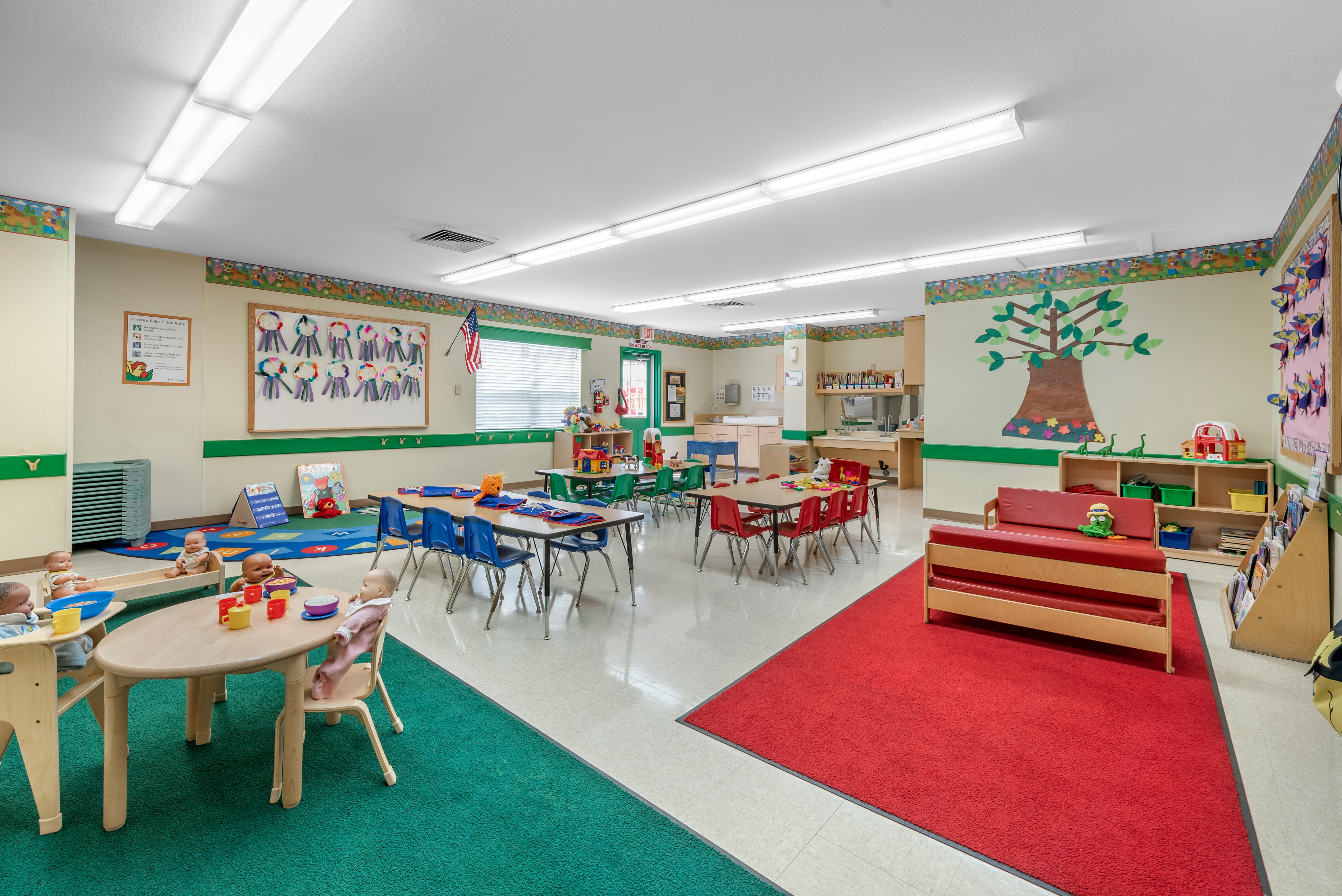 Colorful preschool classroom with various activity stations and child-sized furniture