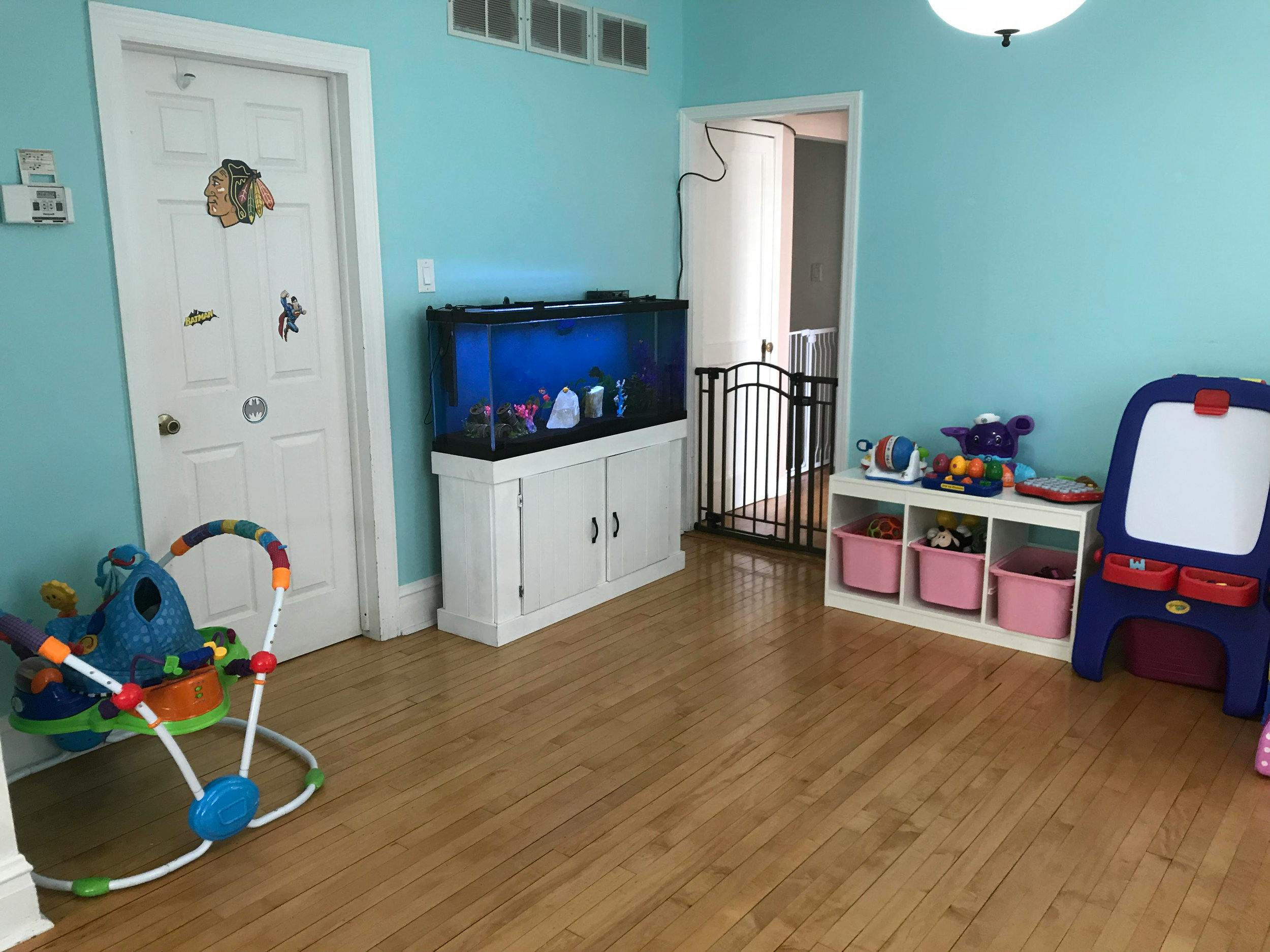 Playroom with an aquarium, baby walker, and toy storage
