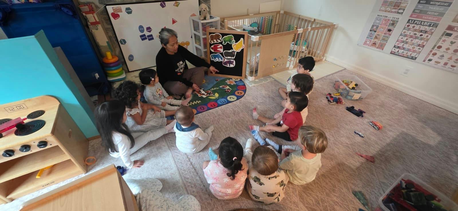 Adult leading a group of children in a floor activity in a classroom
