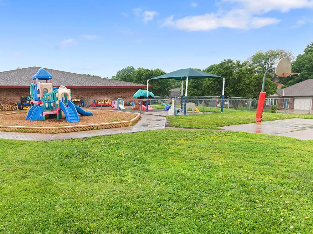 Outdoor playground with slide set and basketball hoop