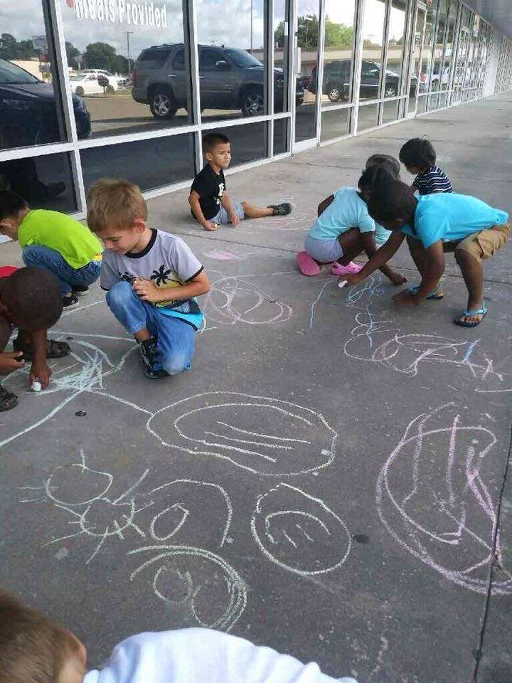 Children drawing with chalk on a sidewalk
