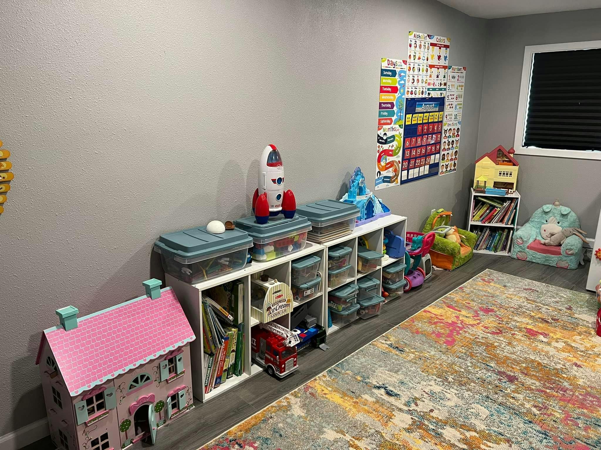 Playroom with dollhouse, toy storage, and colorful rug