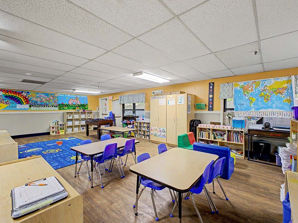 Classroom with tables, chairs, colorful decorations, and a world map