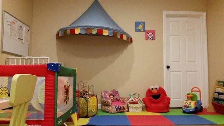 Playroom with colorful mat, toys, and a blue canopy