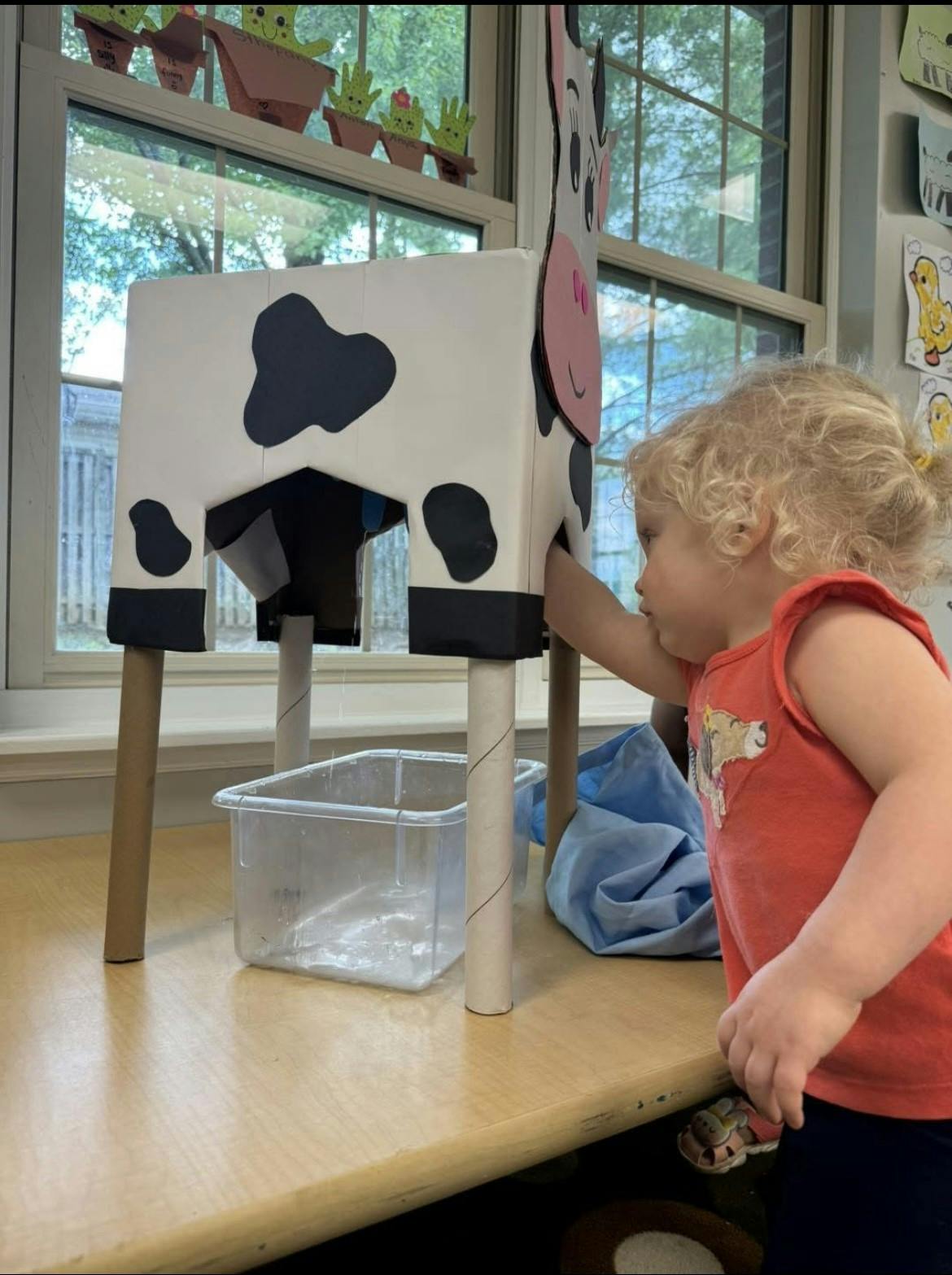 Child playing with a cow-shaped toy