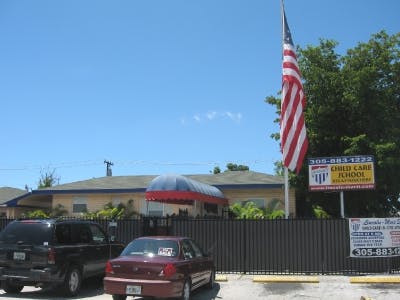 American flag flying next to a building with a sign for a child care school