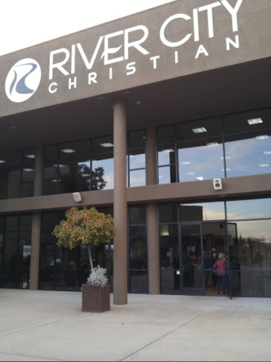 Building with "River City Christian" sign above glass entrance