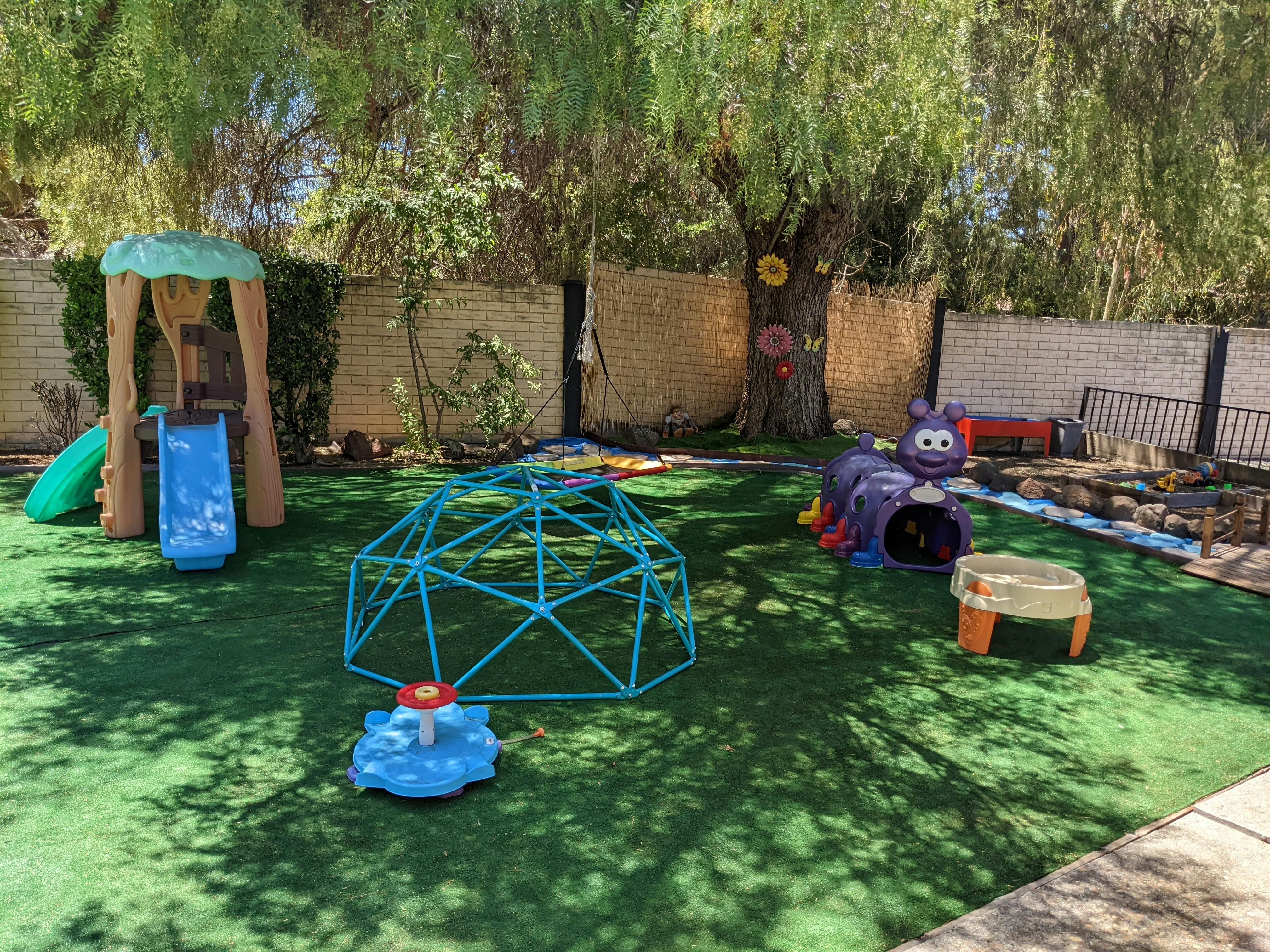 Playground with a slide, climbing dome, and caterpillar tunnel