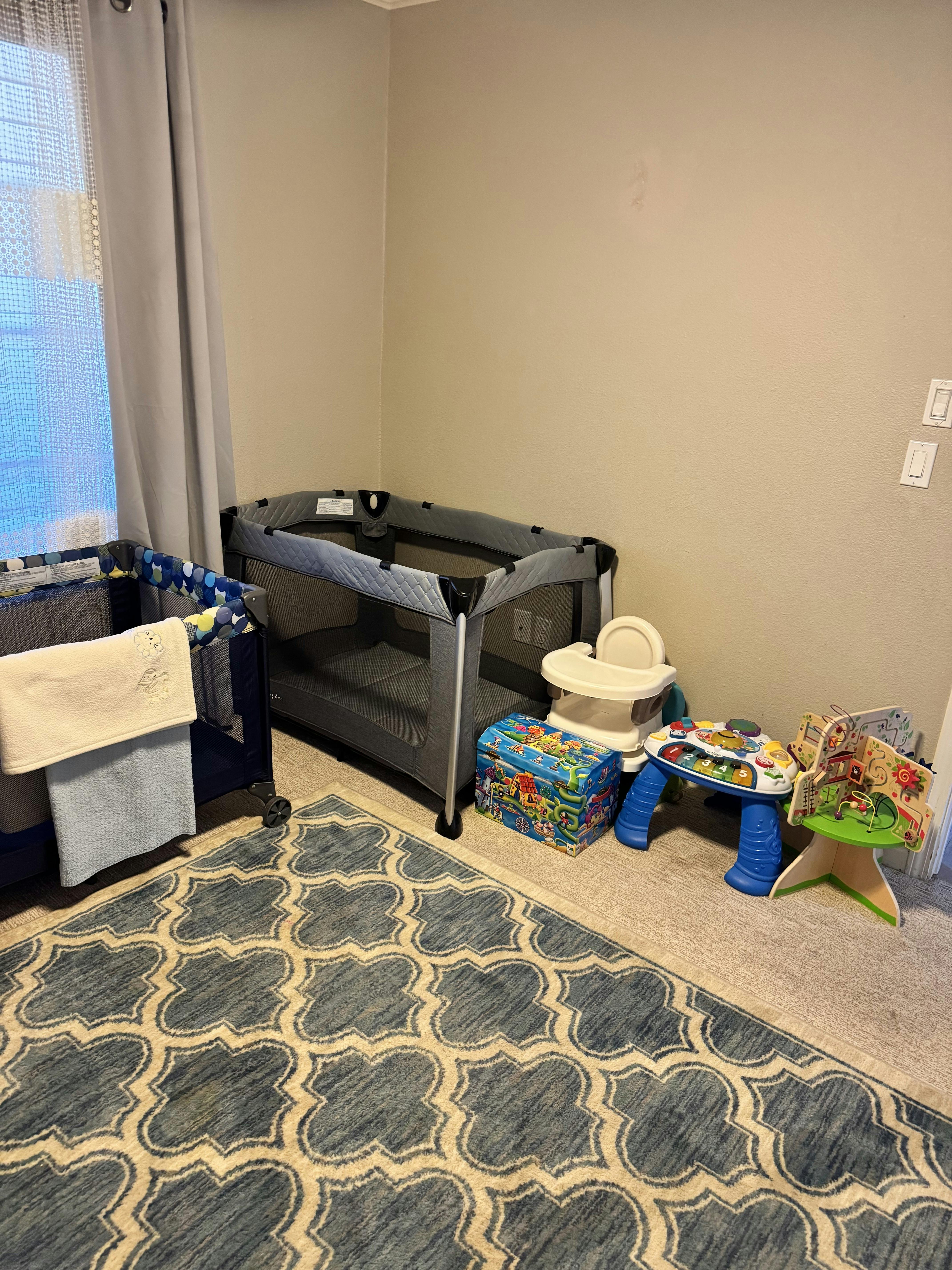 Playpens and various child toys in a room corner