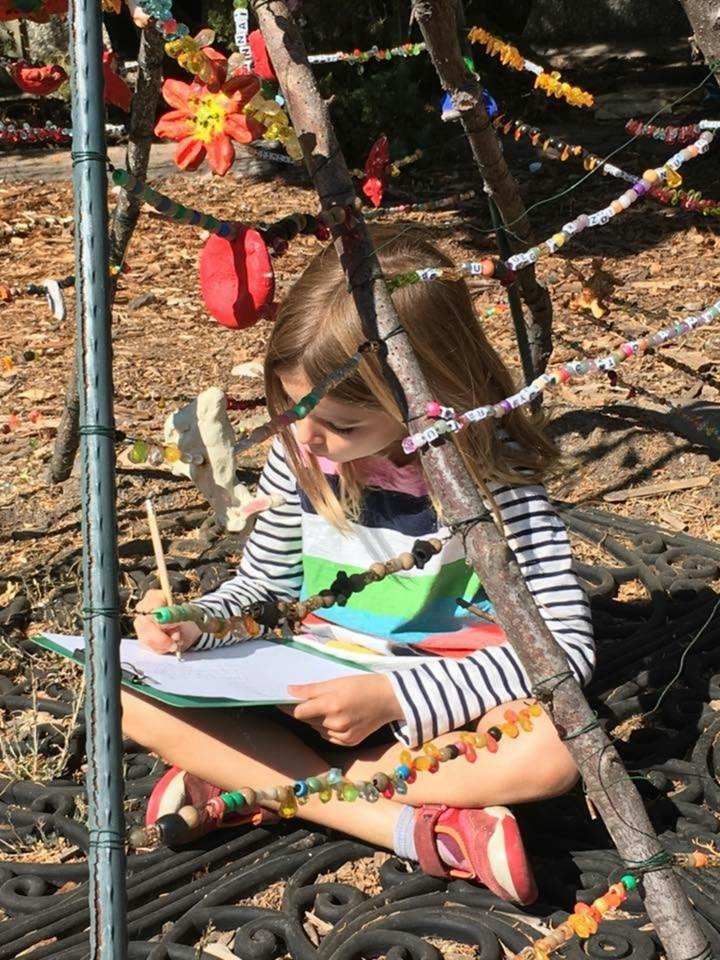 Child drawing on a clipboard outdoors