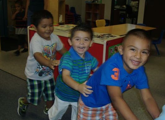 Three children playing together in a line