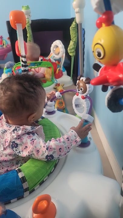 Child in a floral shirt playing with a toy