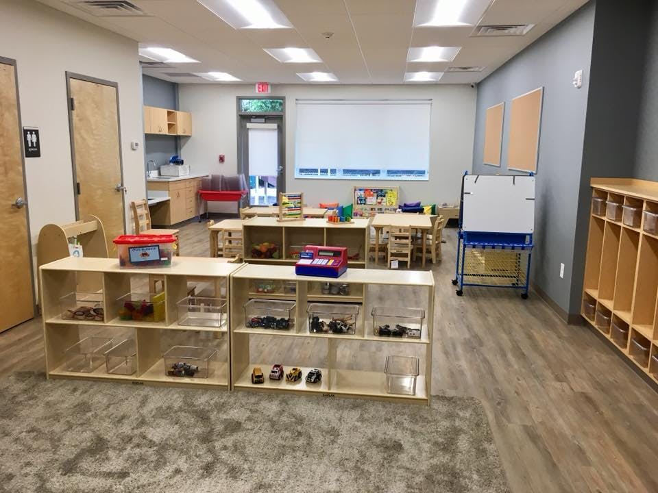Classroom with tables, chairs, shelves, and cubbies