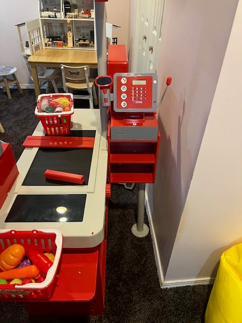 Toy grocery store checkout counter with baskets of play food