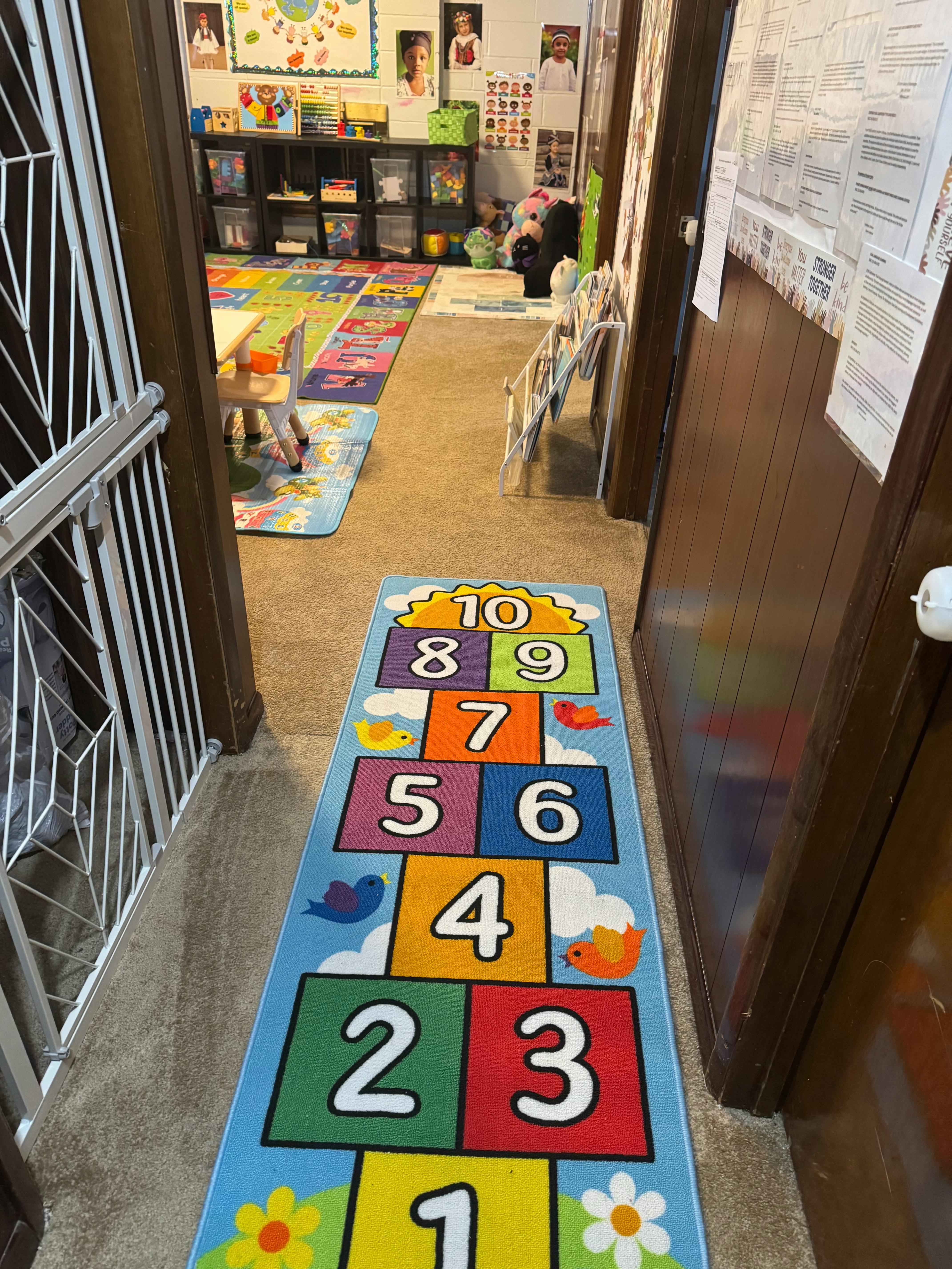 Hopscotch rug in a hallway leading to a classroom