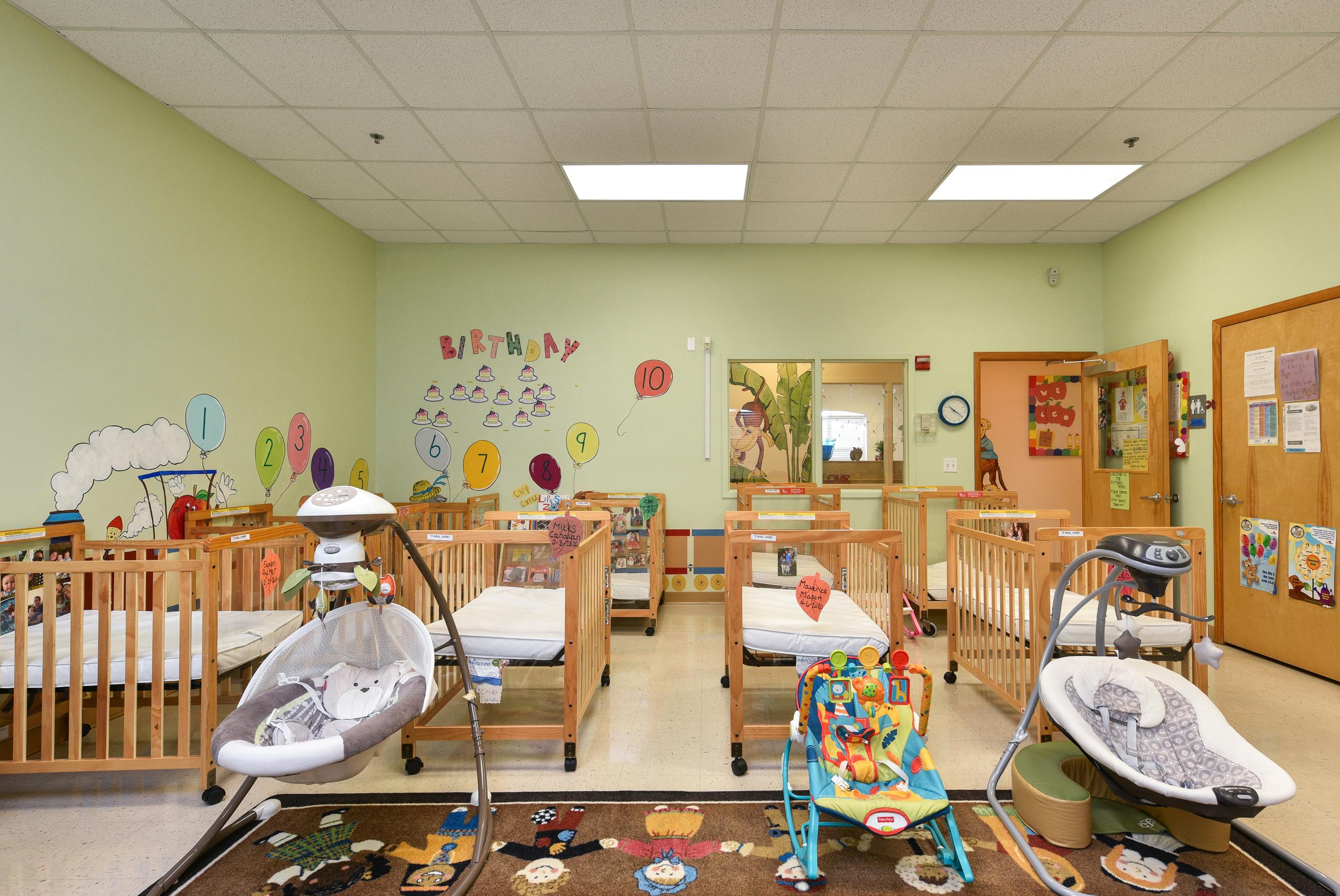 Nursery room with multiple cribs and baby swings