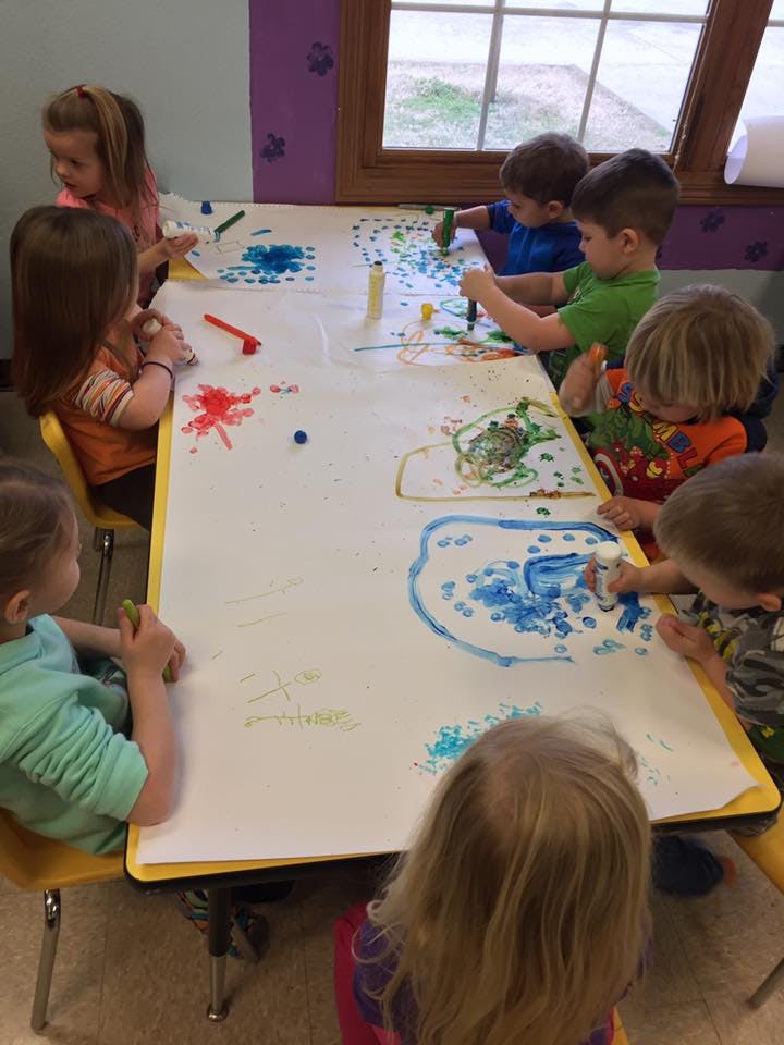 Children painting at a table
