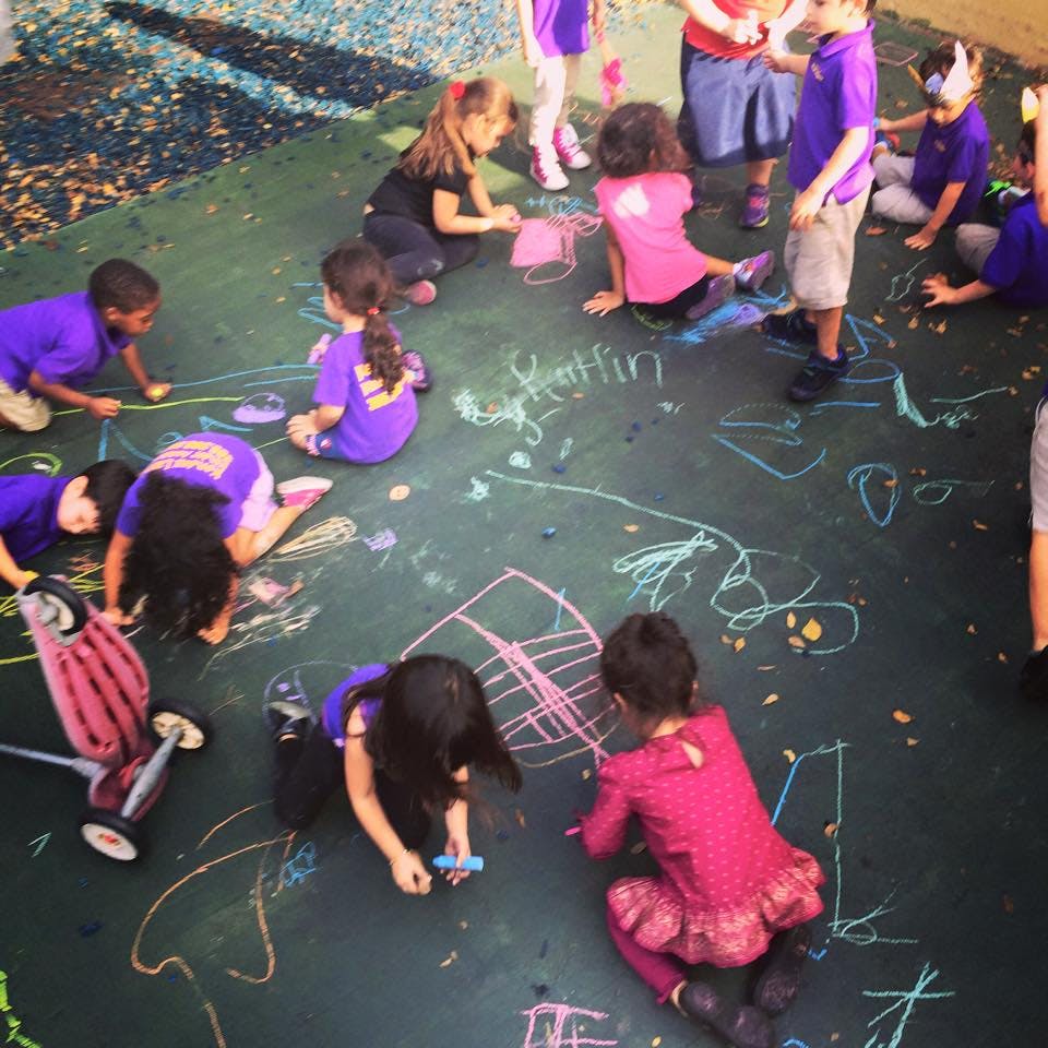 Children drawing with chalk on a dark surface