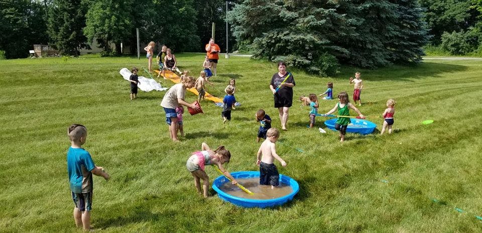 Children playing with water in a grassy area