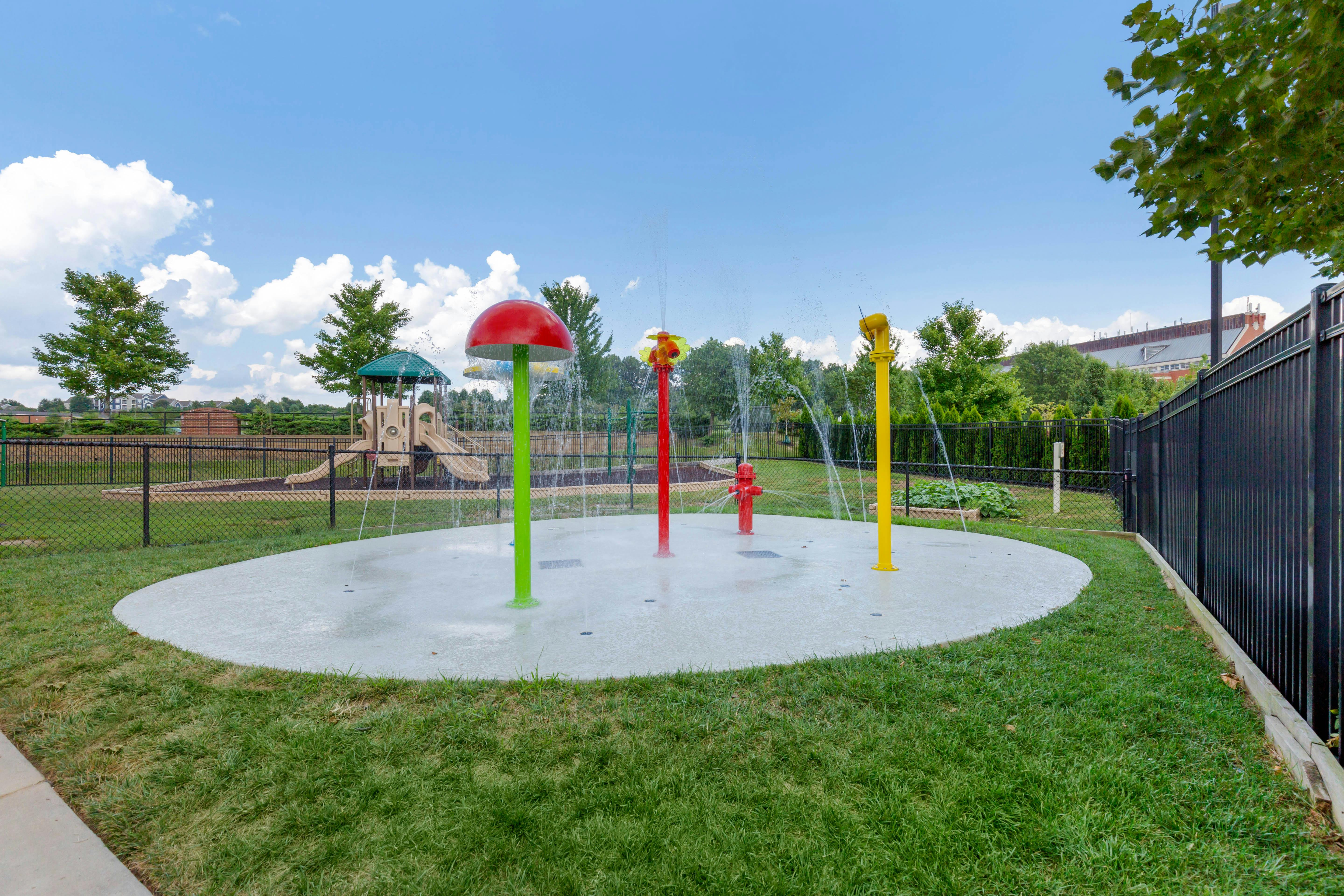 splash pad with water features and playground in background