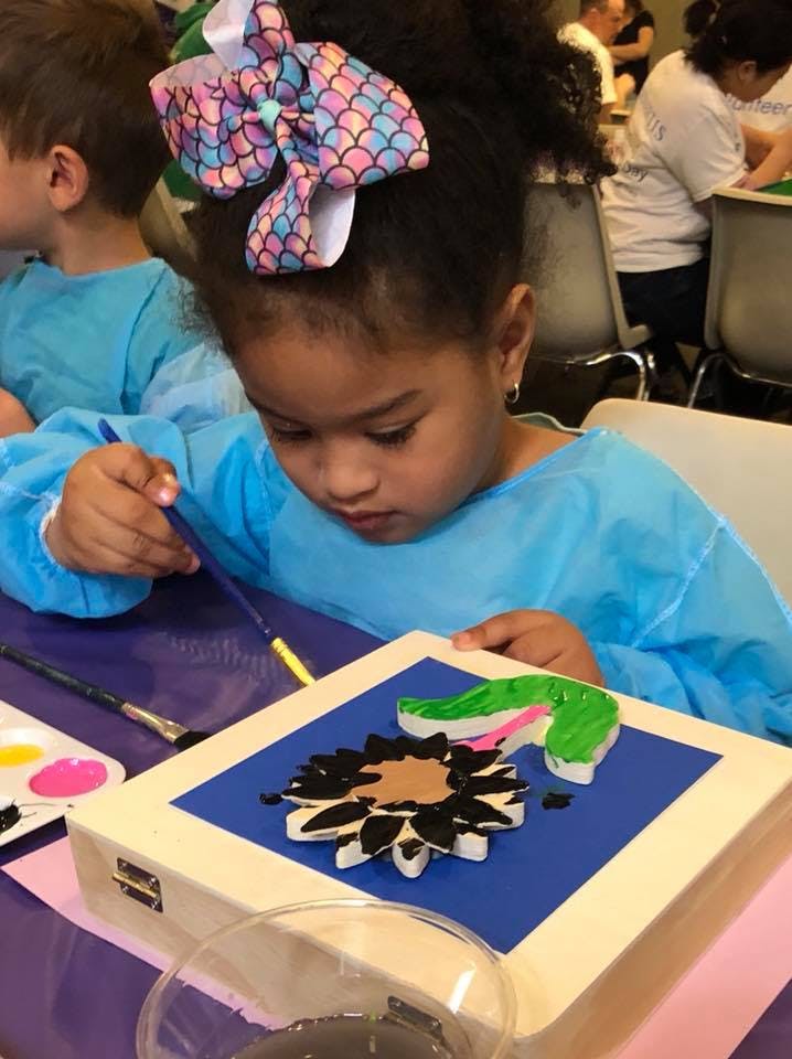 Child painting a sunflower craft