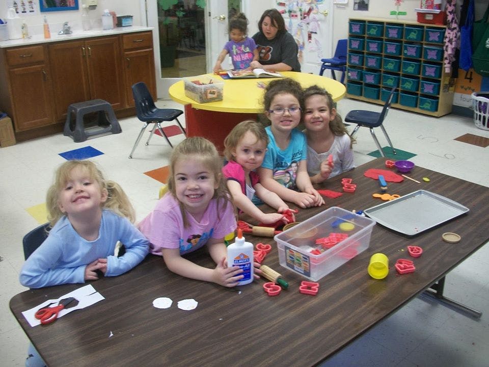 Children at a table with craft supplies in a classroom
