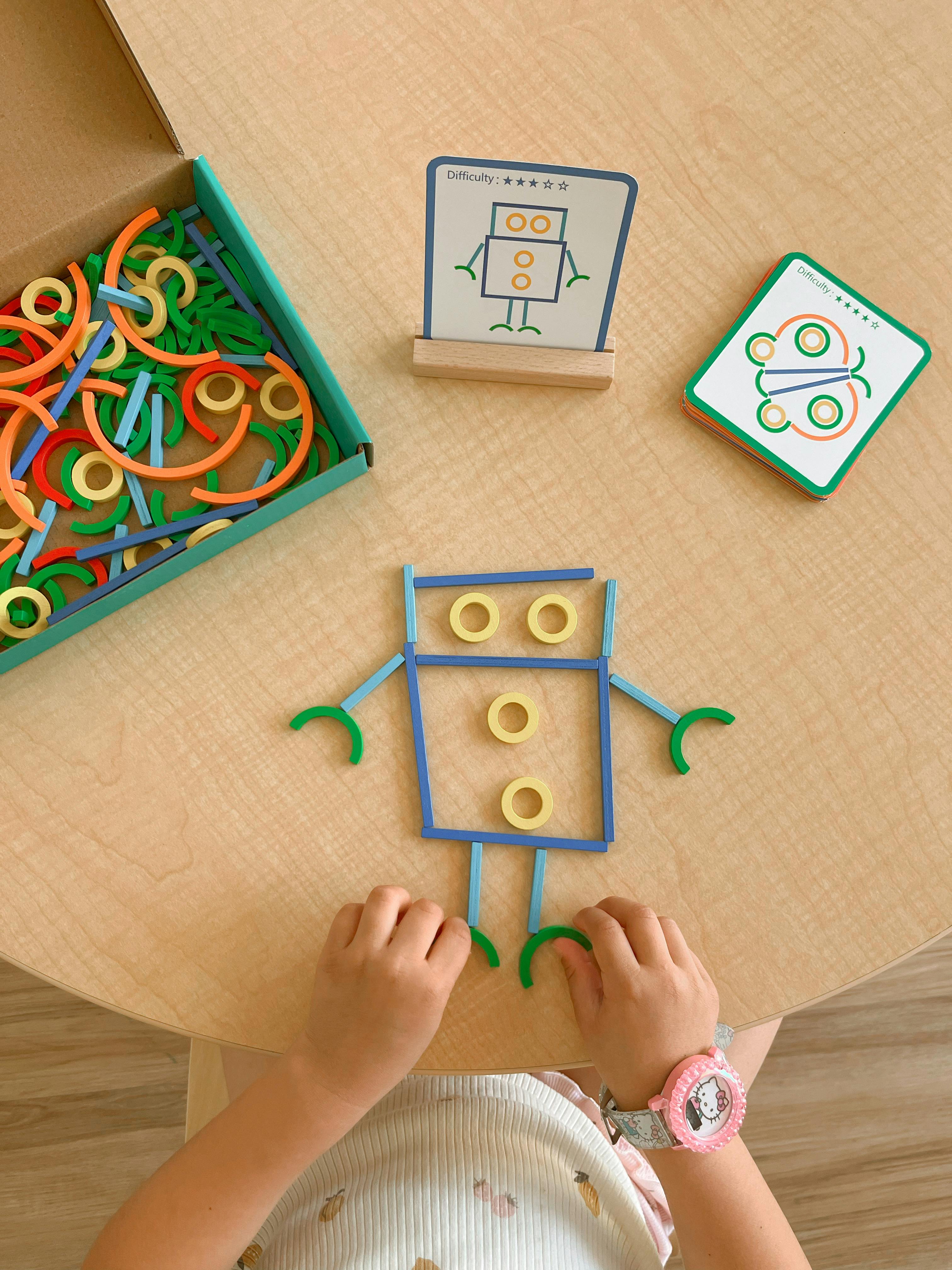 Child playing with colorful building blocks to form a robot shape