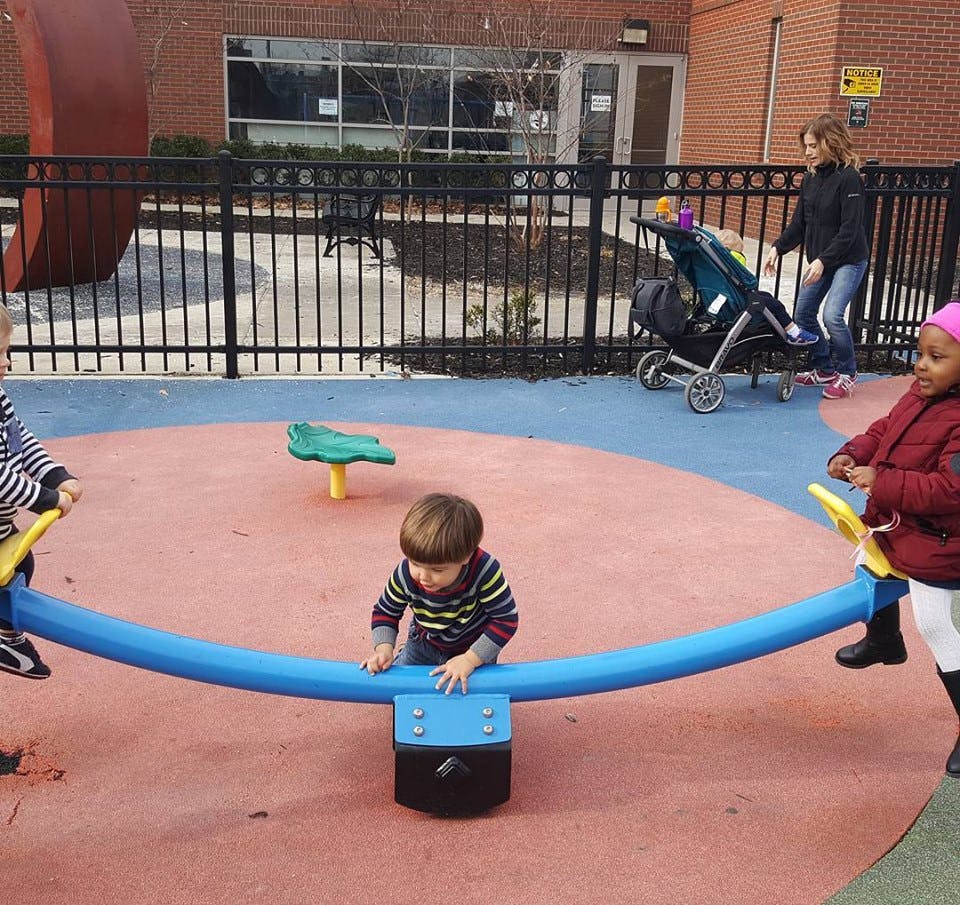 Children playing on a seesaw in a playground