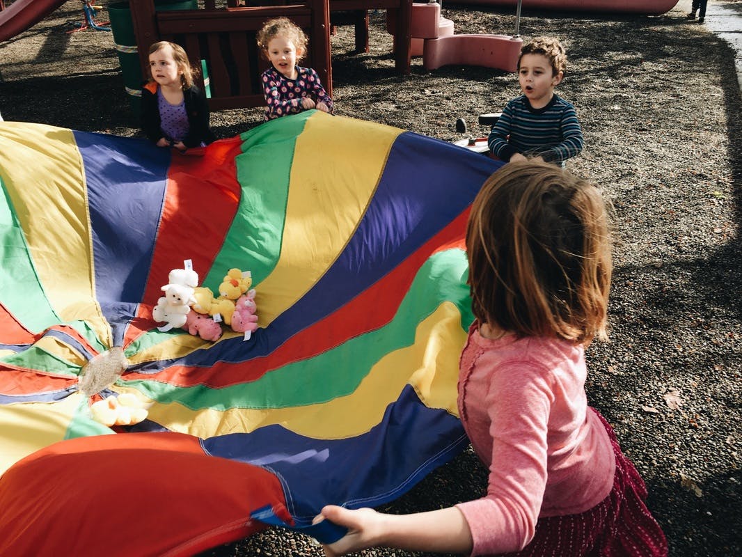 Children playing with a colorful parachute