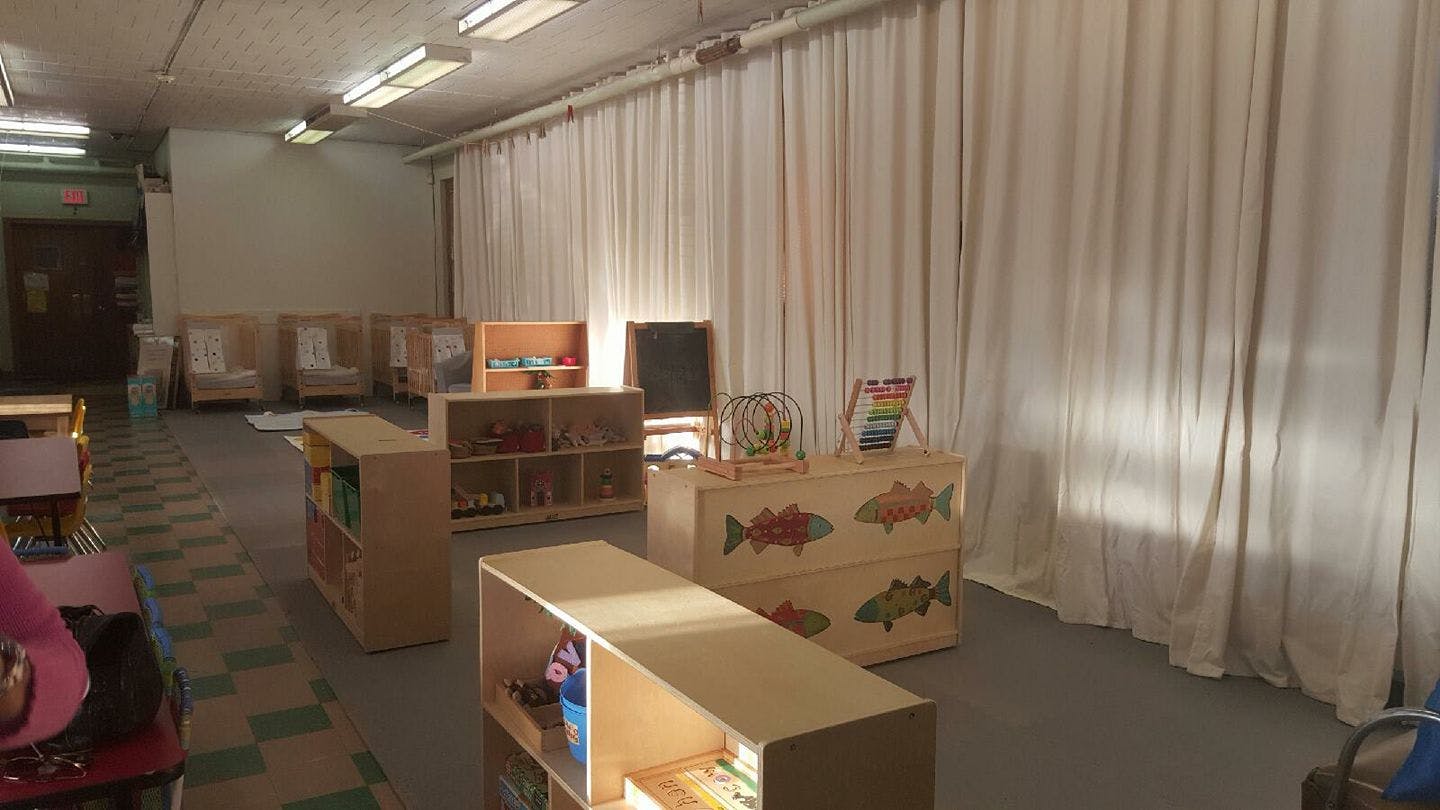 Classroom with wooden shelves and white curtains