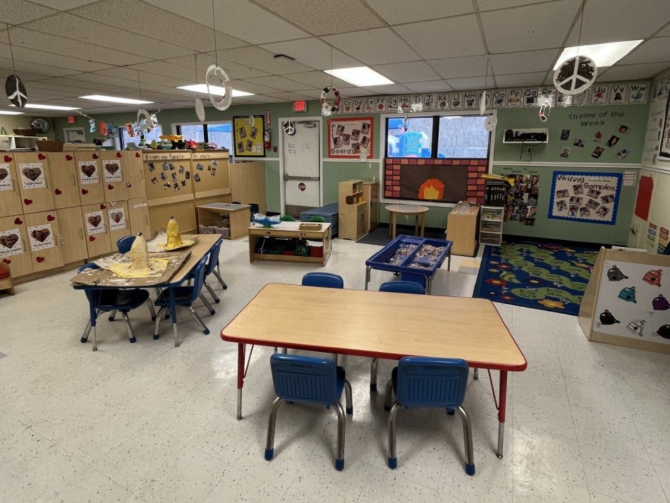 Classroom with small tables and chairs, shelves, and decorations