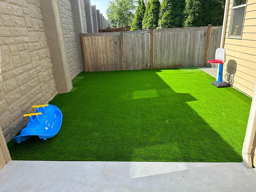 Backyard with artificial turf, a blue slide, and a small basketball hoop