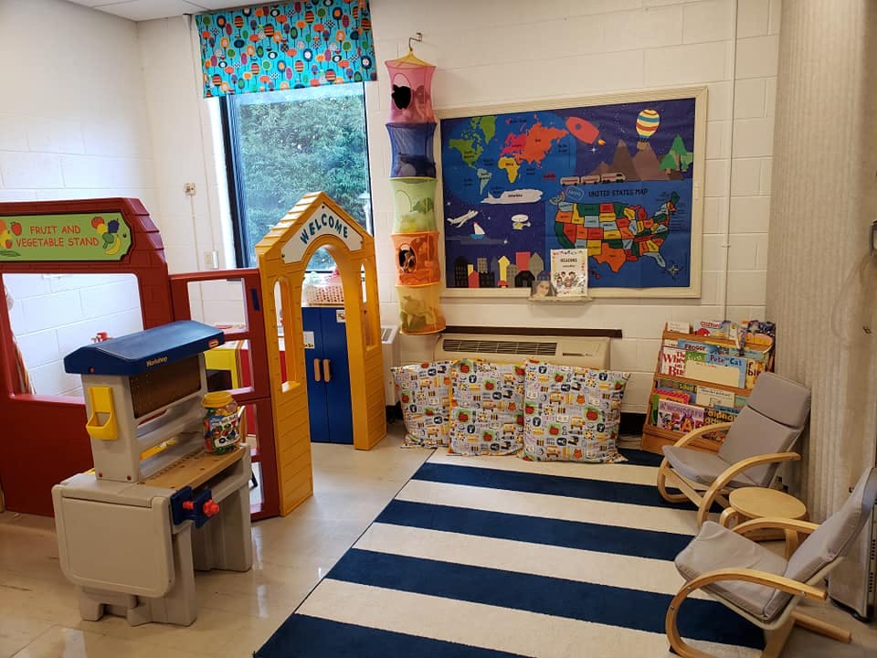 Playroom with a blue and white striped rug, play kitchen, and world map