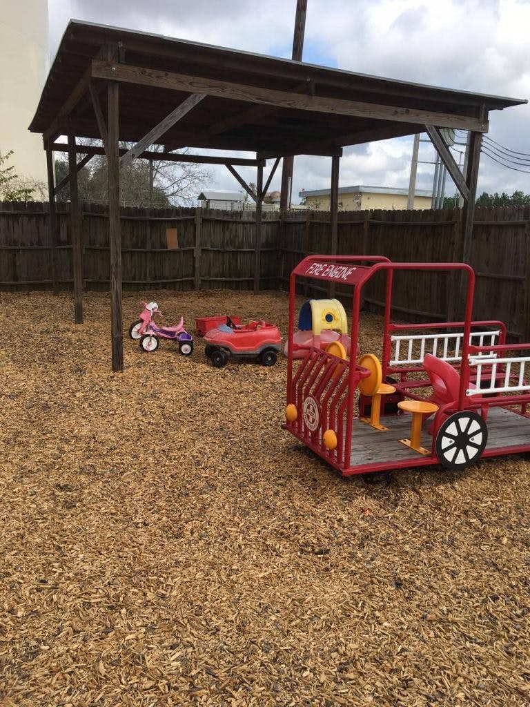 Playground with a wooden shelter and red fire engine play structure