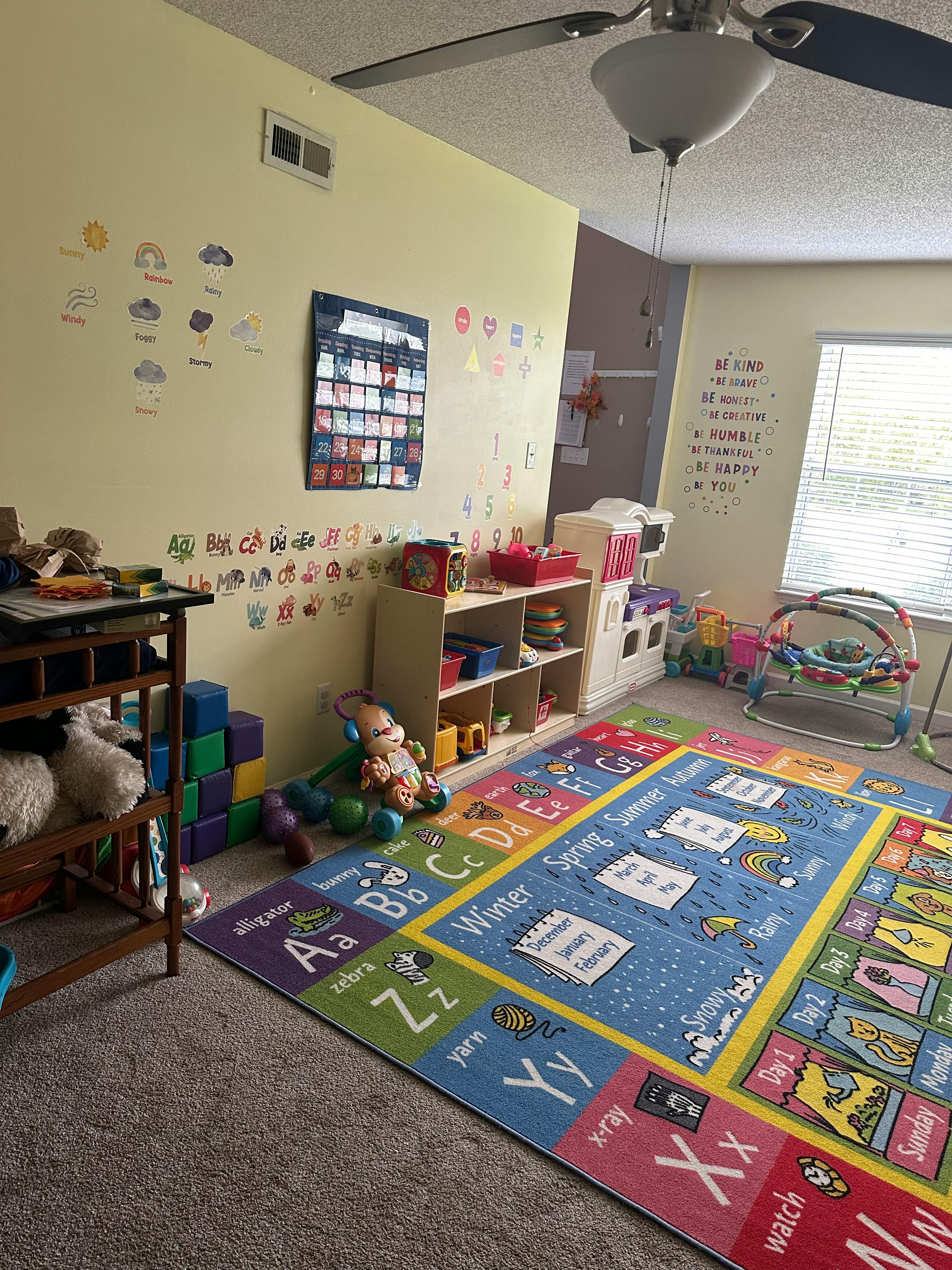 Playroom with alphabet rug, toys, and wall decorations