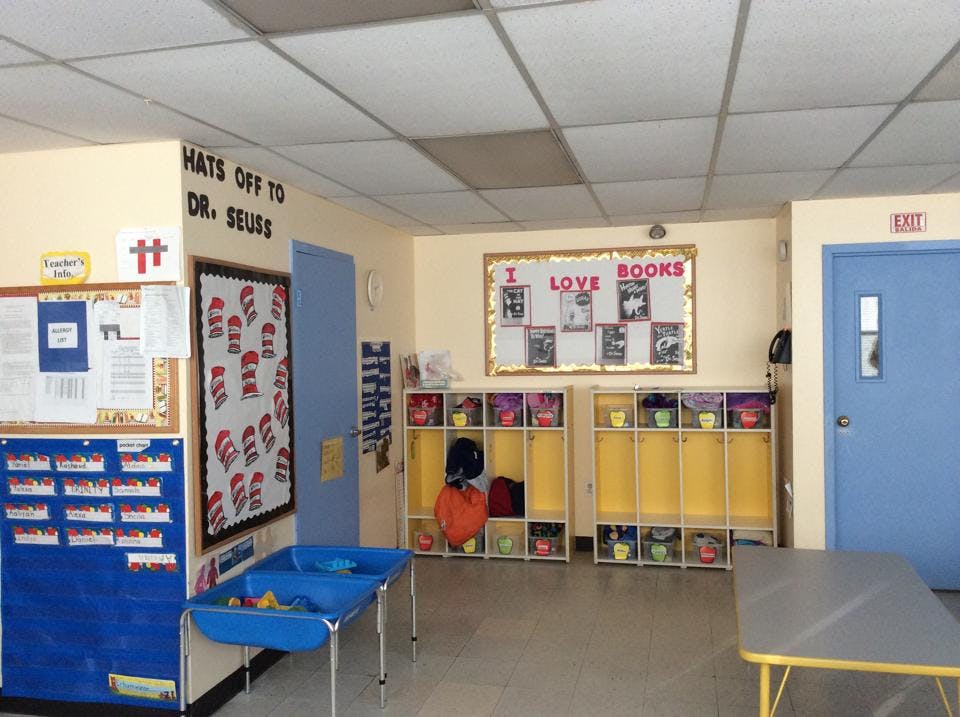 Classroom with bulletin boards, cubbies, and blue tables