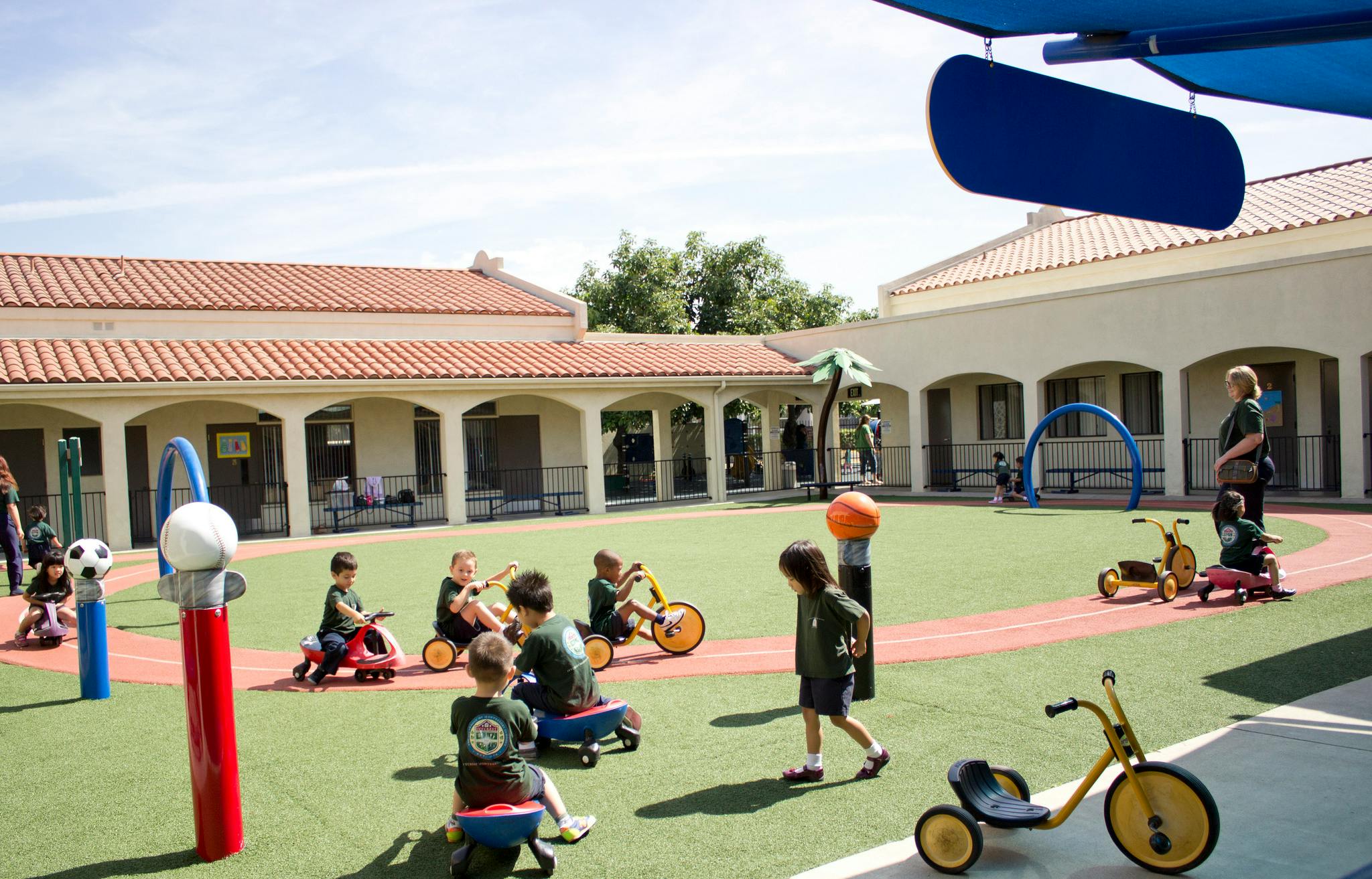 Children playing on tricycles and scooters on a playground