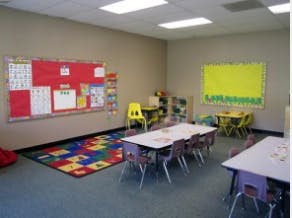 Classroom with tables, chairs, and bulletin boards